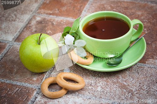 Image of Cup of tea with an apple