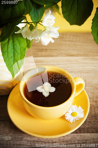 Image of Cup of tea and a bouquet of blooming Jasmine