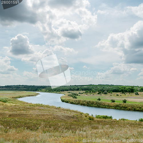 Image of dramatic sky over green landscape with river