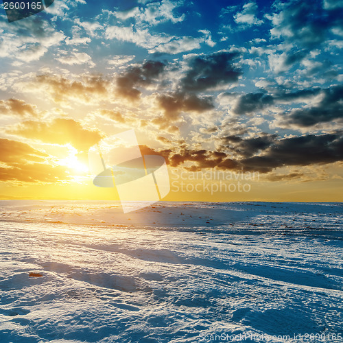 Image of orange sunset over meadow in winter