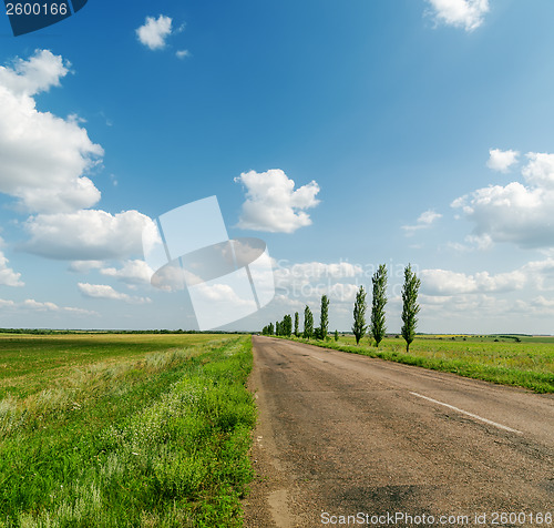 Image of asphalt road in green landscape and blue sky