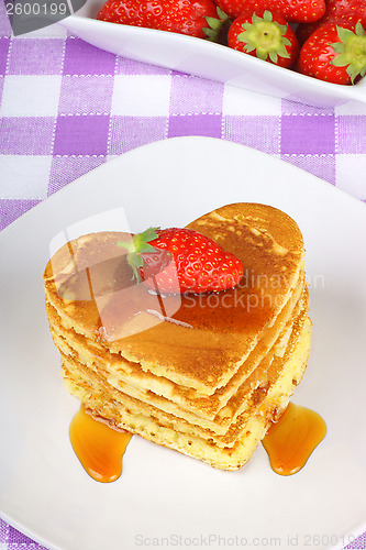 Image of Stack of heart-shaped pancakes with syrup and strawberry