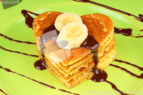 Image of Stack of heart shaped pancakes with chocolate and banana