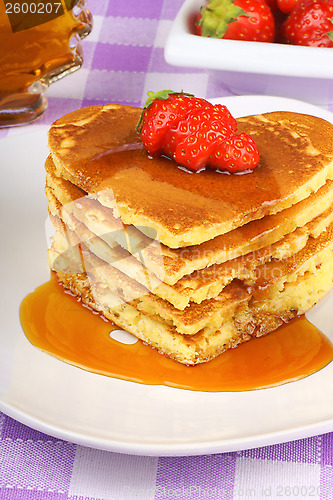 Image of Stack of heart shaped pancakes with syrup and strawberry