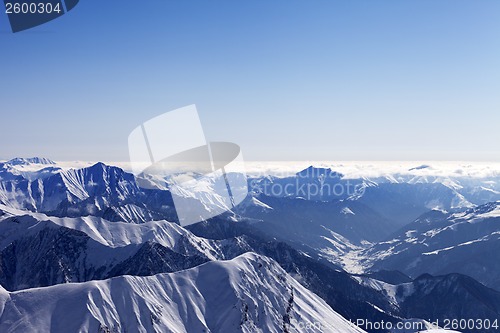 Image of View from off-piste slope on snowy rocks in haze