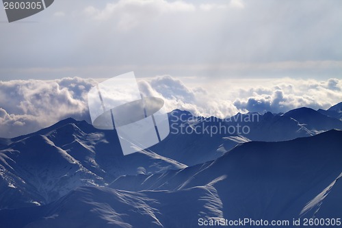 Image of Silhouette of evening mountains in fog