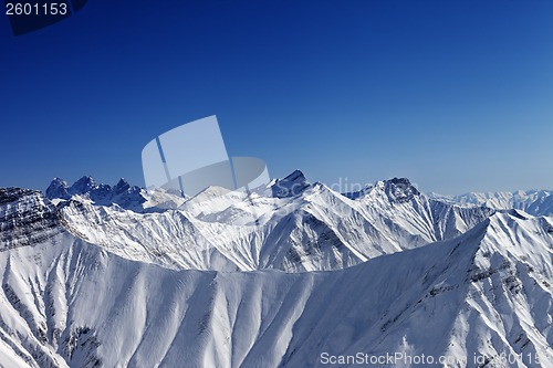 Image of Snowy winter rocks in sun day, view from ski slope