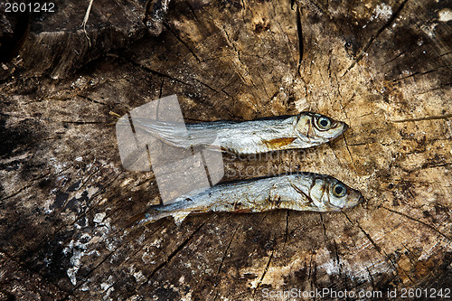 Image of Two small dried fishes on  wood