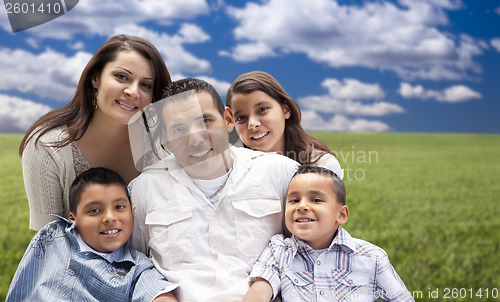 Image of Hispanic Family Portrait Sitting in Grass Field