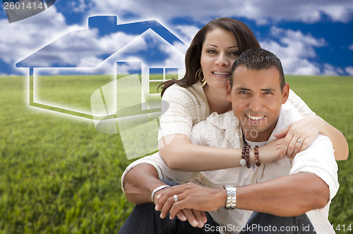 Image of Hispanic Couple Sitting in Grass Field with Ghosted House Behind