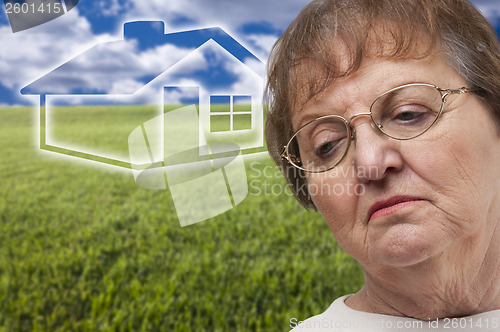 Image of Melancholy Senior Woman with Grass Field and Ghosted House Behin