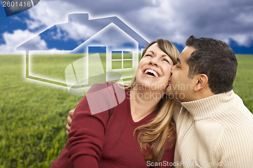 Image of Happy Couple Sitting in Grass Field with Ghosted House Behind