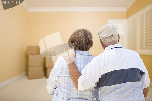 Image of Senior Couple In Room Looking at Moving Boxes on Floor