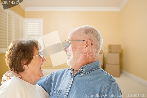 Image of Happy Senior Couple In Room with Moving Boxes on Floor