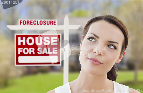 Image of Mixed Race Woman In Front of House and Foreclosure Sign