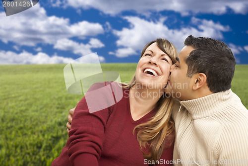 Image of Happy Mixed Couple Sitting in Grass Field 