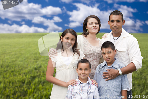 Image of Hispanic Family Portrait Standing in Grass Field