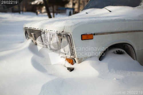 Image of White old car covered with snow