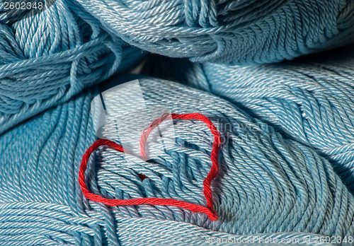 Image of Knitted red heart on blue