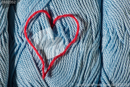 Image of Knitted red heart on blue