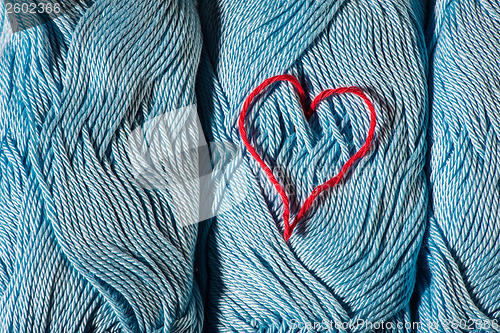 Image of Knitted red heart on blue