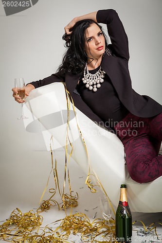 Image of Seductive brunette holding a glass of champagne