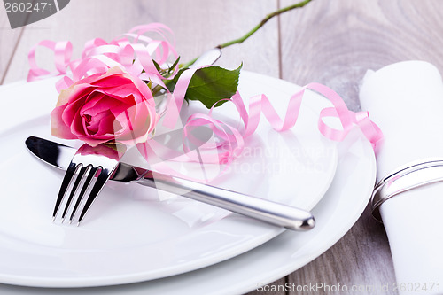 Image of Table setting with a single pink rose