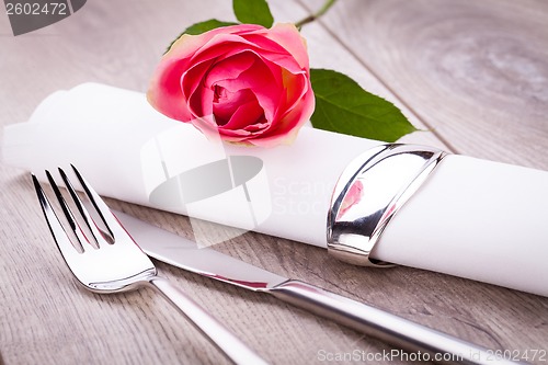 Image of Table setting with a single pink rose