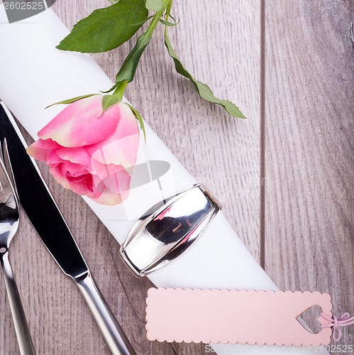 Image of Table setting with a single pink rose