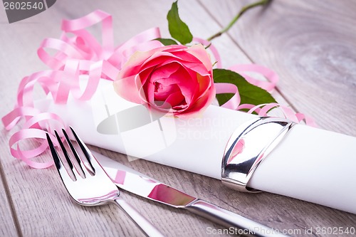 Image of Table setting with a single pink rose