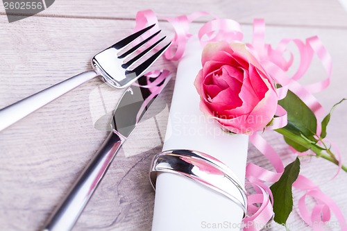 Image of Table setting with a single pink rose