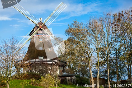 Image of Traditional wooden windmill in a lush garden