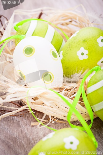 Image of Colourful green Easter eggs in straw