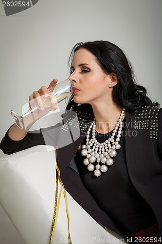 Image of Seductive brunette holding a glass of champagne