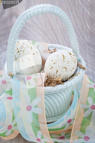 Image of Three natural blue Easter eggs in a basket