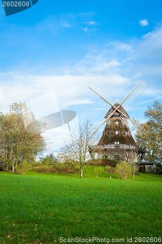 Image of Traditional wooden windmill in a lush garden