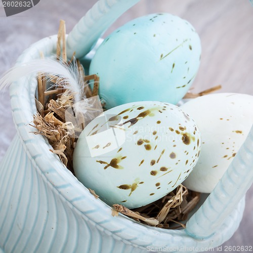 Image of Three natural blue Easter eggs in a basket