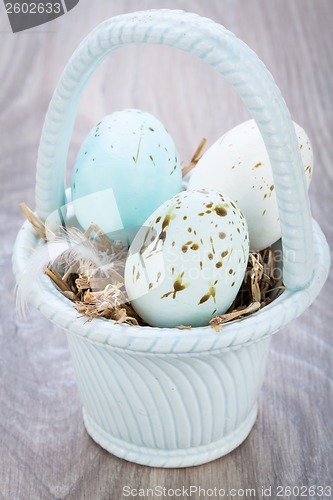 Image of Three natural blue Easter eggs in a basket