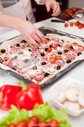 Image of Men cooking fresh italian pizza close up