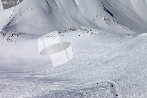 Image of Snowboarders and skiers on slope and off-piste slope with trace 