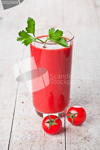 Image of tomato juice in glass and fresh tomatoes 