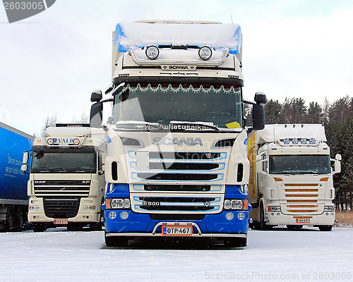 Image of Three Long Haulage Trucks in Snowfall