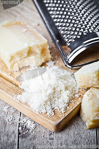 Image of grated parmesan cheese and metal grater