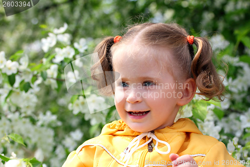 Image of little girl near blossoming apple tree