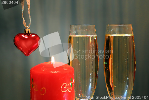 Image of glasses with champagne with heart and candle