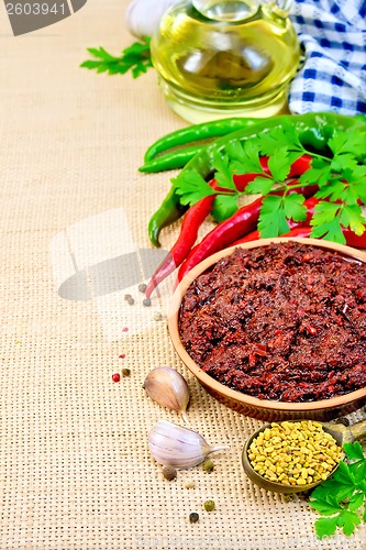 Image of Adjika with hot pepper and a napkin on burlap