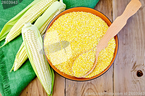 Image of Corn grits with corn cobs on a board