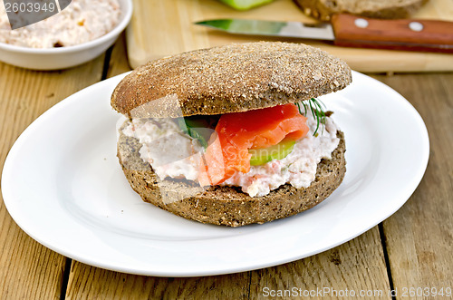 Image of Sandwich with cream and salmon on a board with a knife