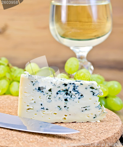 Image of Cheese blue on board with wine and grapes