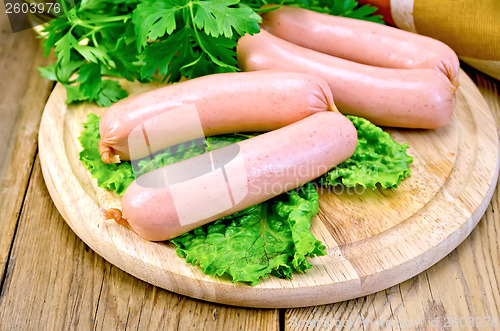 Image of Sausages on board with parsley and napkin